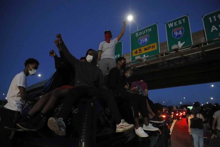 Protesters move along a highway on Friday in Minneapolis after a curfew began. Protests continued following the death of George Floyd who died after being restrained by Minneapolis police officers on Memorial Day.