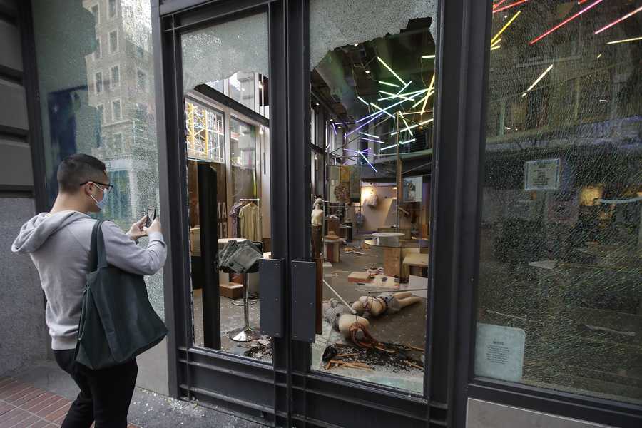 A man photographs damage at an Urban Outfitters store in San Francisco, Sunday, May 31, 2020, after protests over the Memorial Day death of George Floyd, a black man who was killed in police custody in Minneapolis on May 25. A man photographs damage at an Urban Outfitters store in San Francisco, Sunday, May 31, 2020, after protests over the Memorial Day death of George Floyd, a black man who was killed in police custody in Minneapolis on May 25.
