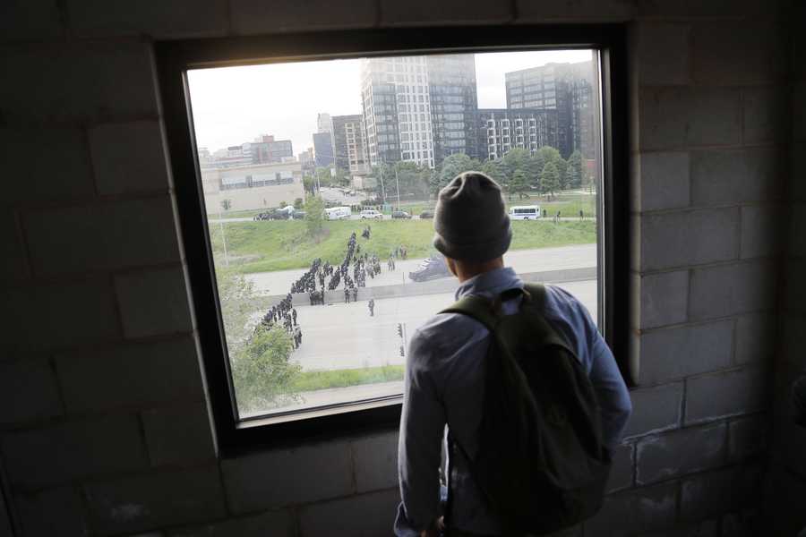 A police force is viewed from a building as they prepare to clear the streets after curfew Sunday, May 31, 2020, in Minneapolis. Protests continued following the death of George Floyd, who died after being restrained by Minneapolis police officers on Memorial Day. (AP Photo/Julio Cortez)