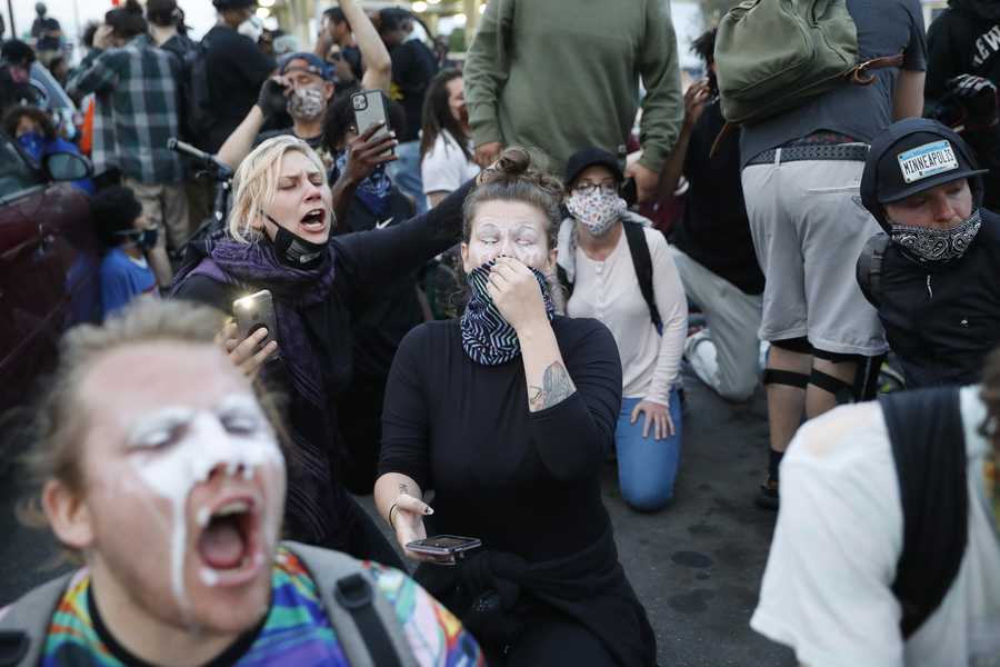 People react to pepper spray after curfew on Sunday, May 31, 2020 in Minneapolis. Protests continue across the United States over the death of George Floyd, a black man who died after being restrained by Minneapolis police officers on May 25. (AP Photo/John Minchillo)