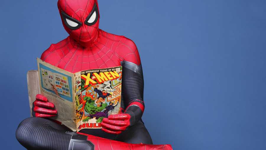 FILE: Evan Nuzum, dressed as Spider-Man, of Escondido, Calif., reads a comic book as he poses for a portrait on day one of Comic-Con International on Thursday, July 18, 2019, in San Diego. (Photo by Rebecca Cabage/Invision/AP)