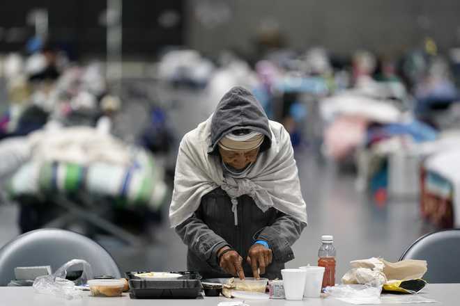 A&#x20;woman&#x20;eats&#x20;at&#x20;a&#x20;homeless&#x20;shelter&#x20;inside&#x20;the&#x20;San&#x20;Diego&#x20;Convention&#x20;Center&#x20;Tuesday,&#x20;Aug.&#x20;11,&#x20;2020,&#x20;in&#x20;San&#x20;Diego.