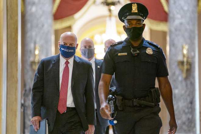 In this Aug. 5, 2020, file photo Postmaster General Louis DeJoy, left, is escorted to House Speaker Nancy Pelosi's office on Capitol Hill in Washington.