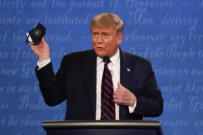 President&#x20;Donald&#x20;Trump&#x20;holds&#x20;up&#x20;his&#x20;face&#x20;mask&#x20;during&#x20;the&#x20;first&#x20;presidential&#x20;debate&#x20;Tuesday,&#x20;Sept.&#x20;29,&#x20;2020,&#x20;at&#x20;Case&#x20;Western&#x20;University&#x20;and&#x20;Cleveland&#x20;Clinic,&#x20;in&#x20;Cleveland,&#x20;Ohio.&#x20;&#x28;AP&#x20;Photo&#x2F;Julio&#x20;Cortez&#x29;