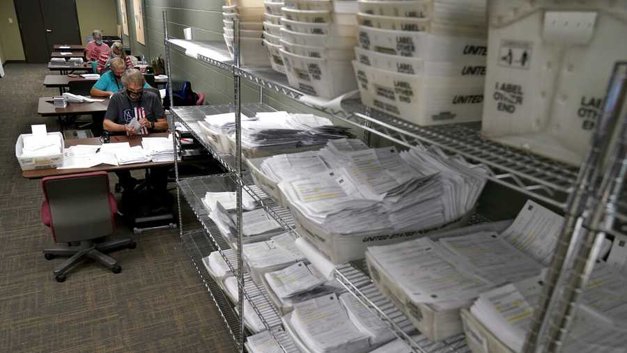 FILE - In this Sept. 22, 2020 file photo, election workers open and sort mail-in ballot requests at the Johnson County election office in Olathe, Kan. Kansas voters will have more options this year to cast their ballot, easing the pressure on fewer available in-person polling sites on Election Day amid pandemic concerns that have closed traditional voting locations in many churches and nursing homes, election officials said. (AP Photo/Charlie Riedel File)