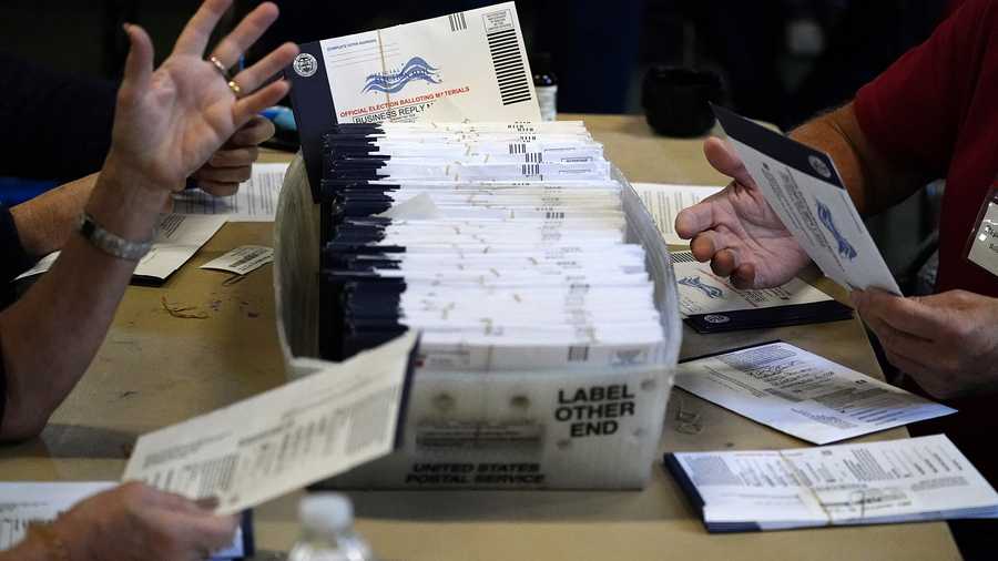 Election workers are shown holding voting materials in this file photo.