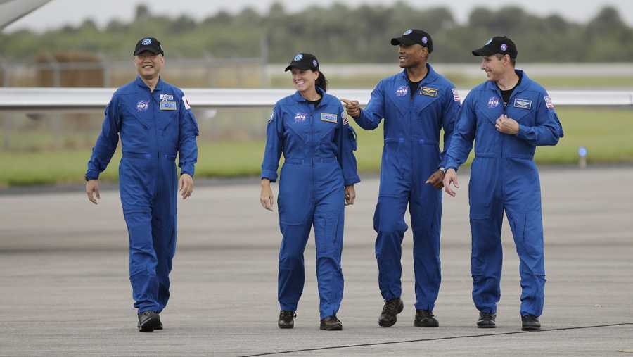 Astronaut Soichi Noguchi, of Japan, from left, NASA Astronauts Shannon Walker, Victor Glover and Michael Hopkins walk after arriving at Kennedy Space Center, Sunday, Nov. 8, 2020, in Cape Canaveral, Fla.