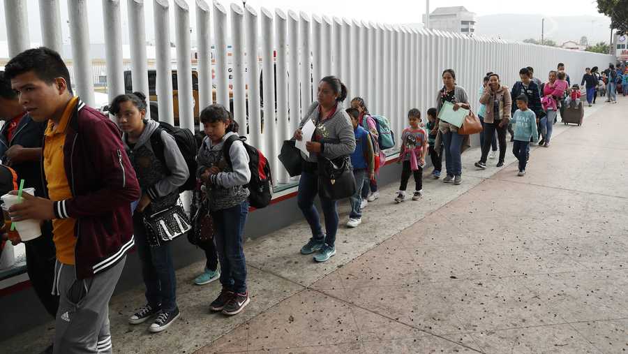 This July 26, 2018, file photo shows people lining up to cross into the United States to begin the process of applying for asylum near the San Ysidro port of entry in Tijuana, Mexico.