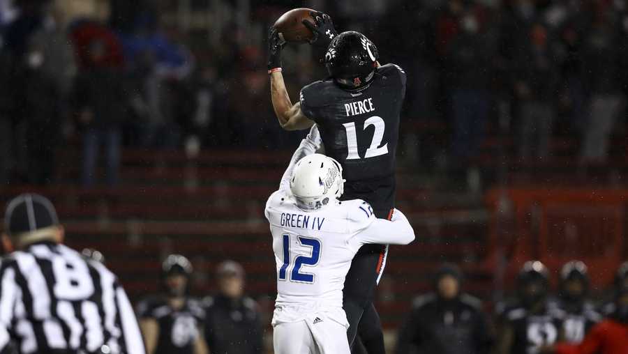 Tulsa cornerback Allie Green IV (12) defends as Cincinnati wide receiver Alec Pierce (12) catches a pass during the first half of the American Athletic Conference championship NCAA college football game, Saturday, Dec. 19, 2020, in Cincinnati. (AP Photo/Aaron Doster)