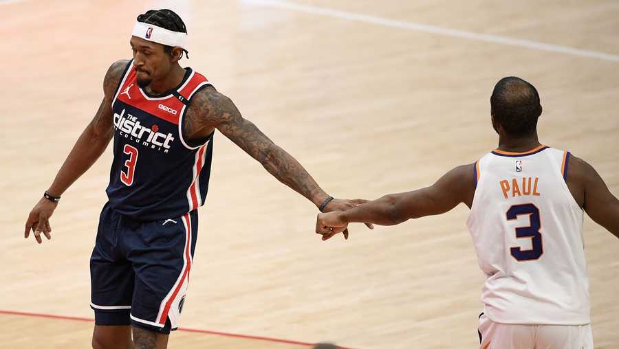 Washington Wizards guard Bradley Beal, left, and Phoenix Suns guard Chris Paul, right, tap hands during the second half of an NBA basketball game, Monday, Jan. 11, 2021, in Washington.