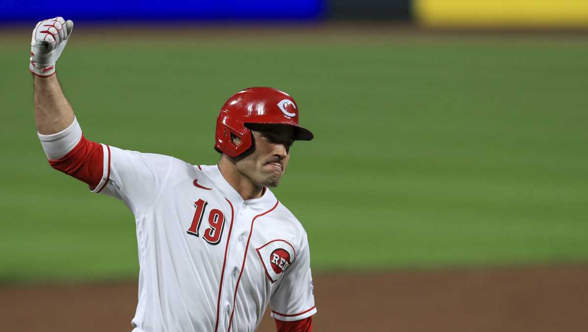 Cincinnati Reds' Joey Votto walks onto the field with his gear prior to a spring  training baseball game against the Chicago Cubs Saturday, March 27, 2021,  in Goodyear, Ariz. (AP Photo/Ross D.