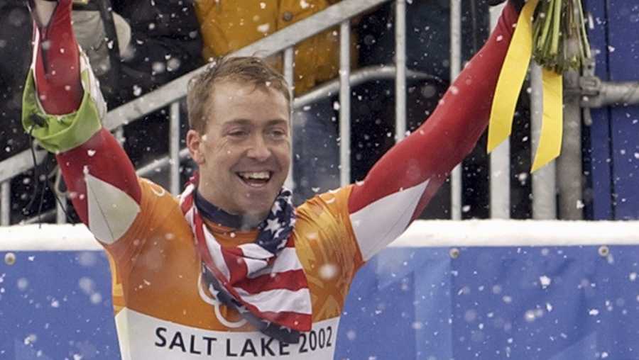 FILE - In this Feb. 20, 2002, file photo, Jimmy Shea of the United States holds a photograph of his grandfather as he celebrates his gold medal winning run after the men's skeleton final at the Salt Lake City Winter Olympics in Park City, Utah. Shea has been charged with sexual abuse of a child in Utah. He made his first court appearance Monday, March 29, 2021, on one count of aggravated sexual abuse of a child and two counts of sexual battery. The alleged abuse occurred in 2020, court documents show.