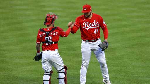 Cincinnati Reds&apos; Tucker Barnhart, left, and Sal Romano congratulate each other after the team&apos;s 9-6 win in a baseball game against the St. Louis Cardinals in Cincinnati, Saturday, April 3, 2021. (AP Photo/Aaron Doster)
