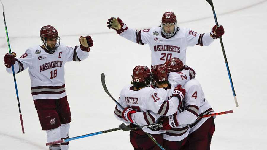 Massachusetts players gather around Zac Jones (24) after he scored against Minnesota Duluth during the first period of an NCAA men&apos;s Frozen Four hockey semifinal in Pittsburgh, Thursday, April 8, 2021. (AP Photo/Keith Srakocic)
