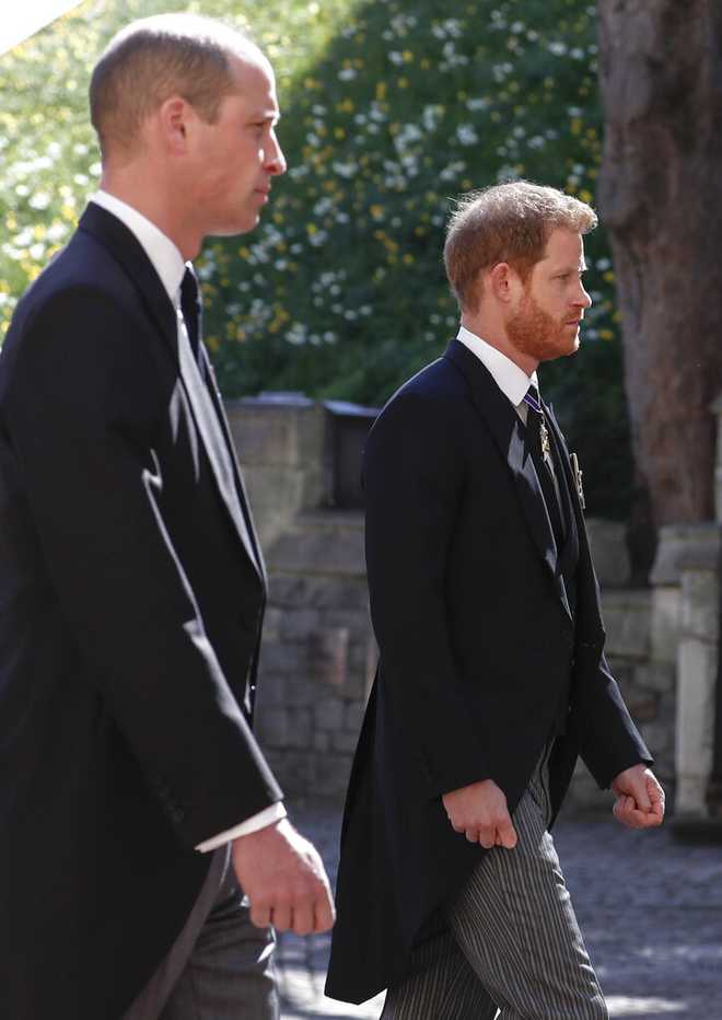 Prince William, left, and Prince Harry follow the coffin in a ceremonial procession for the funeral of Britain's Prince Philip inside Windsor Castle in Windsor, England Saturday April 17, 2021. (Alastair Grant/Pool via AP)