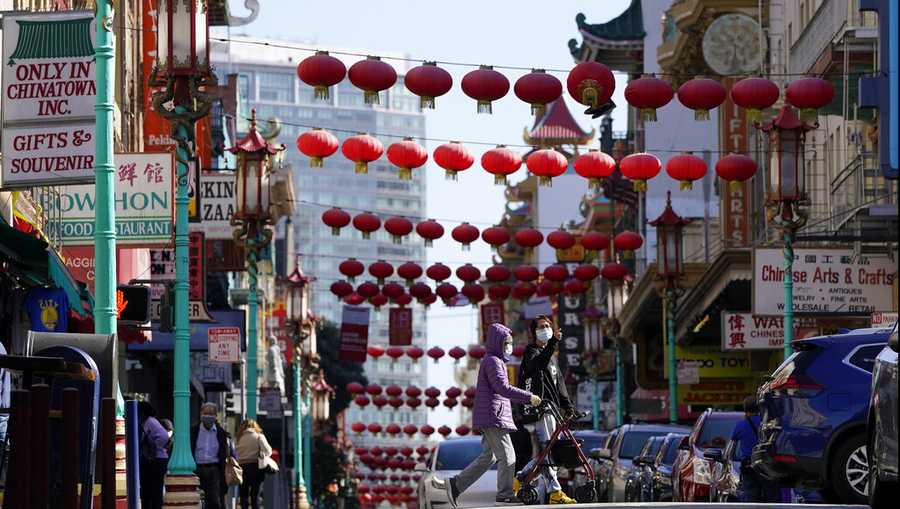 People cross Grant Avenue in Chinatown in San Francisco, Thursday, March 25, 2021. (AP Photo/Jeff Chiu)