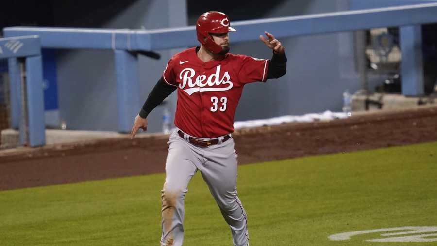 Cincinnati Reds&apos; Jesse Winker (33) runs home to score off of a double hit by Joey Votto during the seventh inning of a baseball game against the Los Angeles Dodgers Tuesday, April 27, 2021, in Los Angeles. Nick Castellanos also scored. (AP Photo/Ashley Landis)