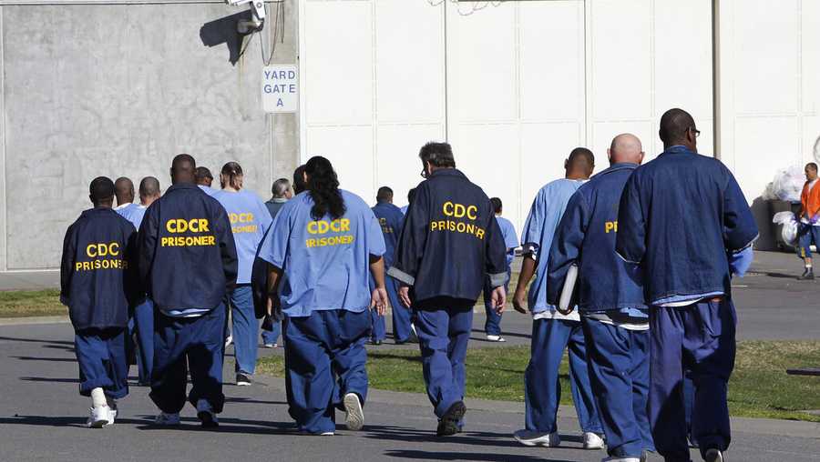 FILE - In this Feb. 26, 2013, file photo, inmates walk through the exercise yard at California State Prison Sacramento, near Folsom, Calif. California is giving 76,000 inmates, including violent and repeat felons, the opportunity to leave prison earlier as the state aims to further trim the population of what once was the nation&apos;s largest state correctional system. The new rules take effect Saturday, May 1, 2021, but it will be months or years before any inmates go free earlier.   (AP Photo/Rich Pedroncelli, File)