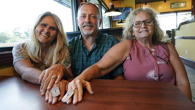 Two days after Debby-Neal Strickland, left, and Jim Merthe, center, were married in November, Debby donated a kidney to Jim's ex-wife Mylaen Merthe, right, as they show off donor/recipient tags they had made during a get together Tuesday, May 25, 2021, at a restaurant in Ocala, Fla.