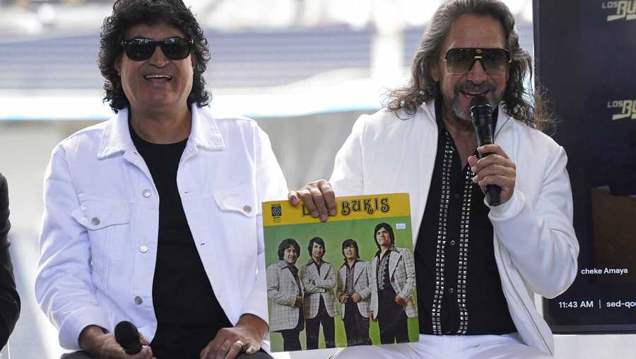 Members of the Mexican grupera band Los Bukis Roberto Guadarrama, left, poses with Marco Antonio Solis as he holds a record at a press conference at SoFi Stadium on Monday, June 14, 2021, in Inglewood, Calif. Twenty five years after their last show as a band, the group announced that they are reuniting for a U.S. tour. (AP Photo/Chris Pizzello)