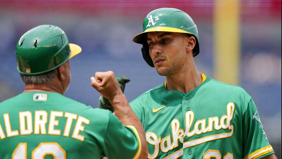 Oakland Athletics&apos; Matt Olson (28) celebrates with first base coach Mike Aldrete (10) after hitting a two-run single off New York Yankees starting pitcher Domingo German in the fifth inning of a baseball game, Saturday, June 19, 2021, in New York. (AP Photo/John Minchillo)