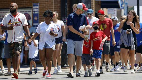 People cross a street as they make their way toward Wrigley Field. (AP Photo/Shafkat Anowar, File)