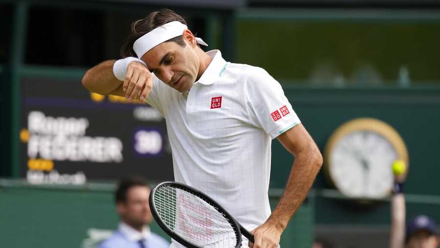 Switzerland's Roger Federer wipes his brow during the men's singles quarterfinals match against Poland's Hubert Hurkacz on day nine of the Wimbledon Tennis Championships in London, Wednesday, July 7, 2021. (AP Photo/Kirsty Wigglesworth)