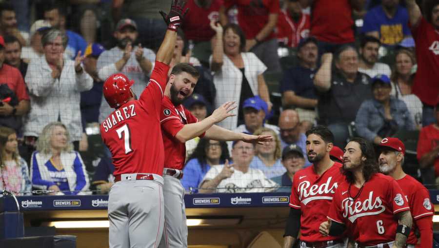 Cincinnati Reds&apos; Eugenio Suarez (7) is congratulated by Jesse Winker after hitting a solo home run during the ninth inning of a baseball game against the Milwaukee Brewers, Saturday, July 10, 2021, in Milwaukee. (AP Photo/Aaron Gash)