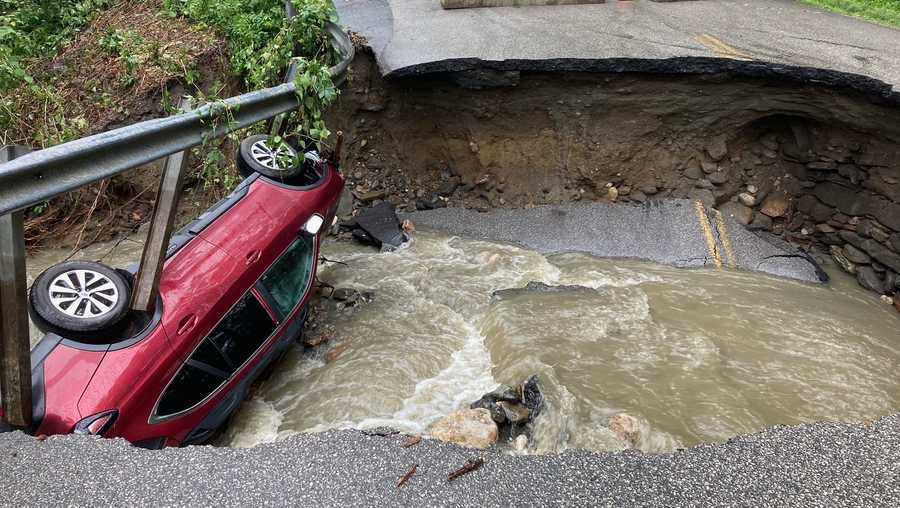 In this photo provided by the Brattleboro (Vermont) Fire Department, floodwaters wash out a bridge and trap a car on Aekly Road in West Brattleboro, Vt., on Saturday, July 17, 2021.  The fire department said Brattleboro received about 2.5 inches of rainfall during Saturday afternoon and night. (Charles Keir/Brattleboro Fire Department via The AP)