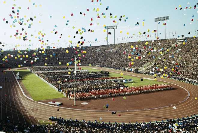 In&#x20;this&#x20;Oct.&#x20;10,&#x20;1964,&#x20;file&#x20;photo,&#x20;balloons&#x20;fly&#x20;over&#x20;Olympians&#x20;and&#x20;spectators&#x20;during&#x20;the&#x20;opening&#x20;ceremony&#x20;of&#x20;the&#x20;1964&#x20;Summer&#x20;Olympics&#x20;at&#x20;the&#x20;National&#x20;Stadium&#x20;in&#x20;Tokyo.