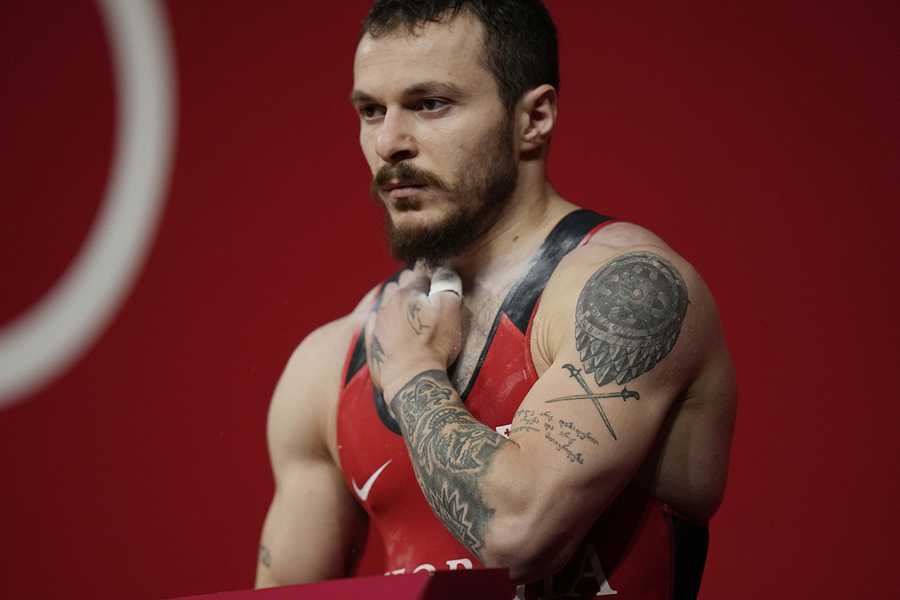 Shota Mishvelidze of Georgia prepares to compete in the men's 61kg weightlifting event, at the 2020 Summer Olympics, Sunday, July 25, 2021, in Tokyo, Japan. (AP Photo/Luca Bruno) Shota Mishvelidze of Georgia prepares to compete in the men's 61kg weightlifting event, at the 2020 Summer Olympics, Sunday, July 25, 2021, in Tokyo, Japan. (AP Photo/Luca Bruno)