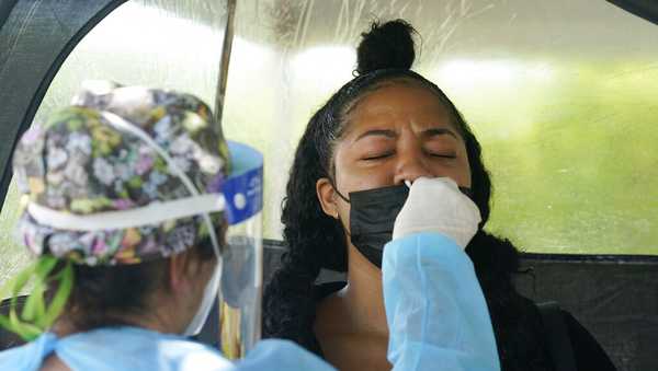 Chantel Powell gets a COVID-19 PCR test in order to travel later this week at a Miami-Dade County testing site, Monday, July 26, 2021, in Miami. More than 73,000 new coronavirus cases were reported in Florida over the previous week, according to the state health department, nearly seven times the 12,000 reported a month ago. (AP Photo/Marta Lavandier)