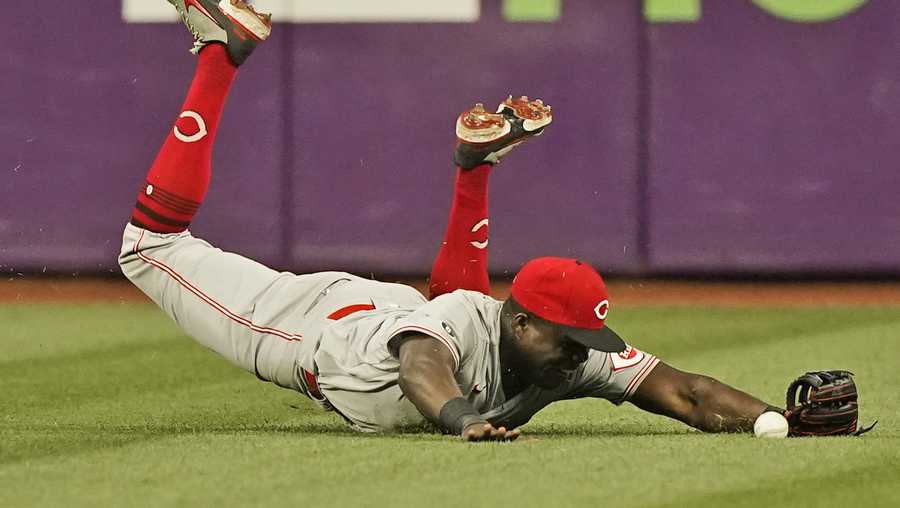Cincinnati Reds' Aristides Aquino dives but cannot catch a double hit by Cleveland Indians' Amed Rosario in the eighth inning of a baseball game, Monday, Aug. 9, 2021, in Cleveland. (AP Photo/Tony Dejak)