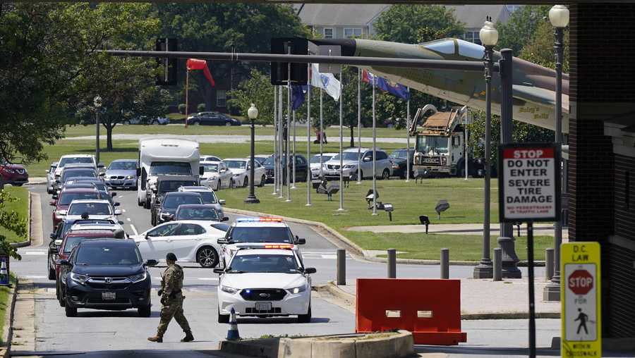 Security personnel stand at an entrance to Joint Base Anacostia-Bolling during a lockdown, Friday, Aug. 13, 2021, in Washington. The base was placed on lockdown after a report that an armed person was spotted on the base. (AP Photo/Patrick Semansky)