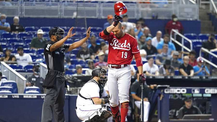 Cincinnati Reds&apos; Joey Votto (19) pauses while batting during the ninth inning of a baseball game against the Miami Marlins, Sunday, Aug. 29, 2021, in Miami. The Marlins won 2-1. At left is umpire Edwin Moscoso. (AP Photo/Lynne Sladky)