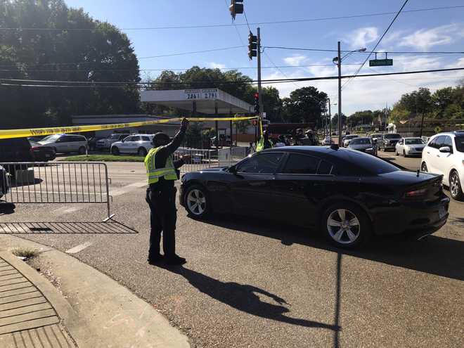 Officers allow a police vehicle to pass under yellow crime scene tape on a street in front of the post office in Memphis. Officers allow a police vehicle to pass under yellow crime scene tape on a street in front of the post office in Memphis.