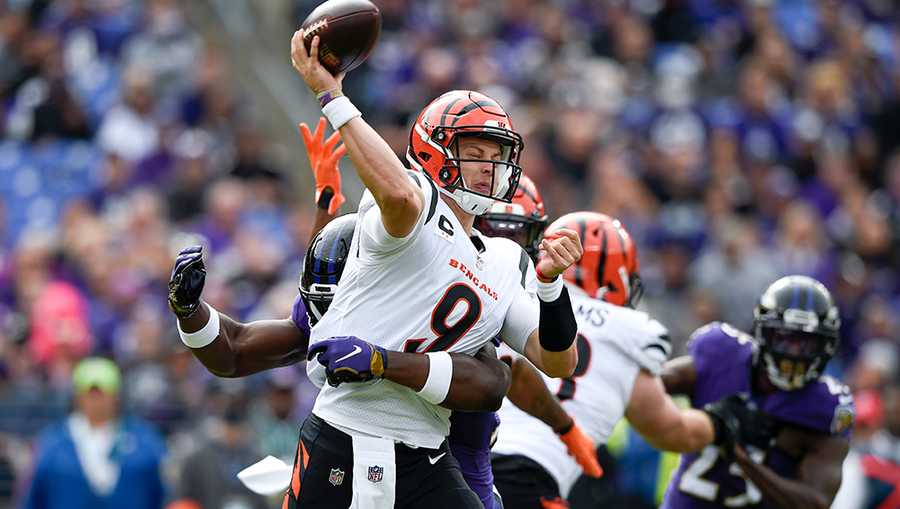 Cincinnati Bengals quarterback Joe Burrow (9) is hit by Baltimore Ravens outside linebacker Justin Houston as he throws a pass during the first half of an NFL football game, Sunday, Oct. 24, 2021, in Baltimore. (AP Photo/Gail Burton)
