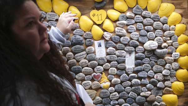 Rima Samman looks for certain names of people who died from coronavirus at Rami's Heart COVID-19 Memorial in Wall Township, N.J., Wednesday, Oct. 27, 2021. (AP Photo/Seth Wenig)