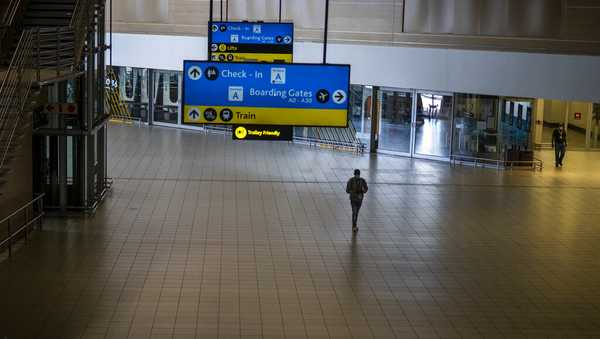 A man walks through a deserted part of Johannesburg's OR Tambo's airport, South Africa, Monday Nov. 29, 2021. The World Health Organisation urged countries around the world not to impose flight bans on southern African nations due to concern over the new omicron variant. (AP Photo/Jerome Delay)