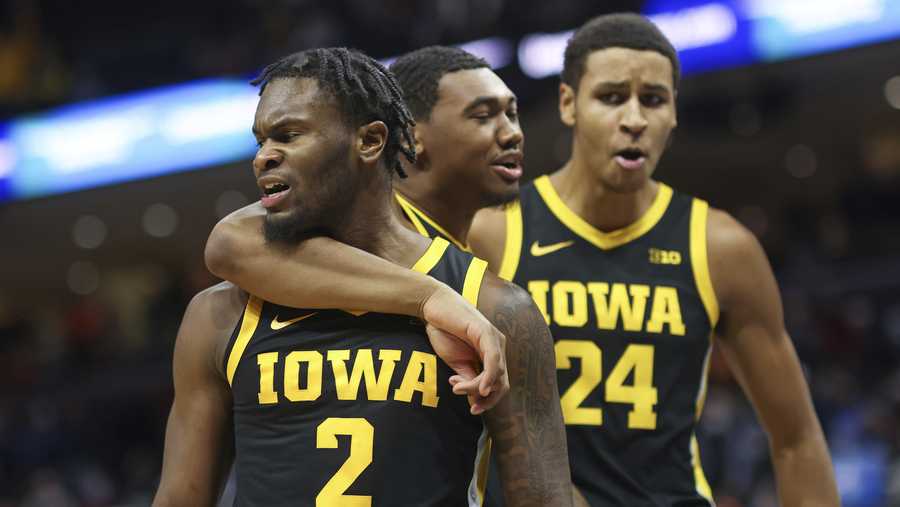 Iowa guard Joe Toussaint (2) celebrates the win over Virginia with teammates Tony Perkins (11) and Kris Murray (24) after an NCAA college basketball game in Charlottesville, Va., Monday, Nov. 29, 2021. Iowa defeated Virginia 75-74. (AP Photo/Andrew Shurtleff)