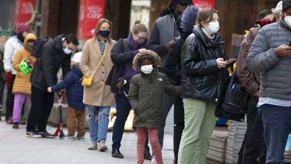 FILE - People wait in line outside a COVID-19 walk-in testing site, Sunday, Dec. 5, 2021, in Cambridge, Mass. More U.S. states desperate to defend against COVID-19 are calling on the National Guard and other military personnel to assist virus-weary medical staffs at hospitals and other care centers. (AP Photo/Michael Dwyer, File)