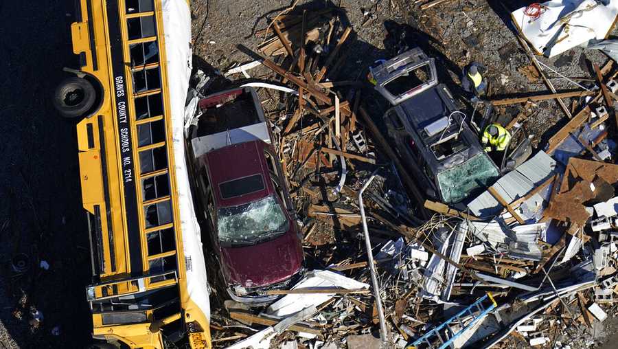 In this aerial photo, responders sift through debris near an overturned school bus in the aftermath of tornadoes that tore through the region, in Mayfield, Ky., Sunday, Dec. 12, 2021. (AP Photo/Gerald Herbert)
