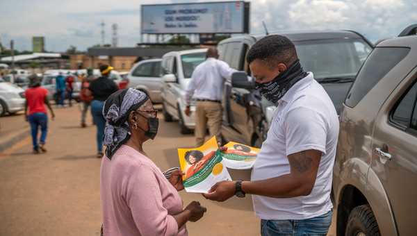 FILE - A Funeral Parlours Association member distributes a leaflet in Soweto, South Africa, Tuesday Dec. 7, 2021. Over 40 hearses took part in what was a COVID-19 vaccine awareness campaign, with the slogan: 