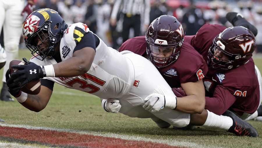 Maryland running back Antwaine Littleton II (31) scores a touchdown past Virginia Tech defensive lineman Josh Fuga (6) during the first half of the Pinstripe Bowl NCAA college football game in New York, Wednesday, Dec. 29, 2021. (AP Photo/Adam Hunger)