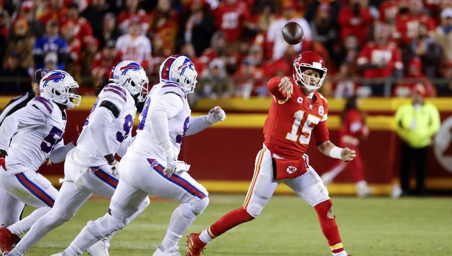 Kansas City Chiefs quarterback Patrick Mahomes (15) throws a pass on the run as he is chased by Buffalo Bills defenders during the second half of an NFL divisional round playoff football game, Sunday, Jan. 23, 2022, in Kansas City, Mo. (AP Photo/Colin E. Braley)