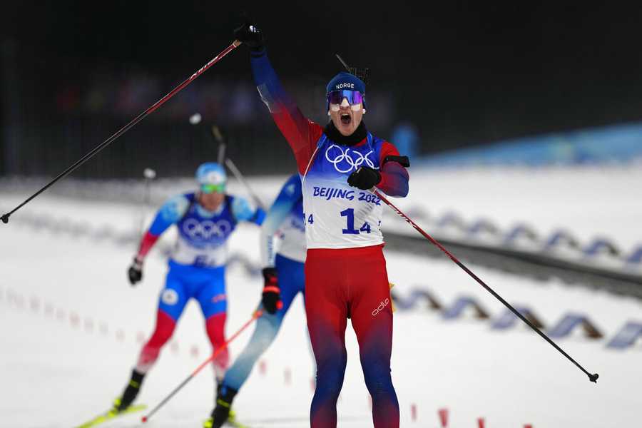 Biathlon Johannes Thingnes Boe of Norway raises his arms after crossing the finish line in first during the 4x6-kilometer mixed relay at the 2022 Winter Olympics, Saturday, Feb. 5, 2022, in Zhangjiakou, China. (AP Photo/Kirsty Wigglesworth)