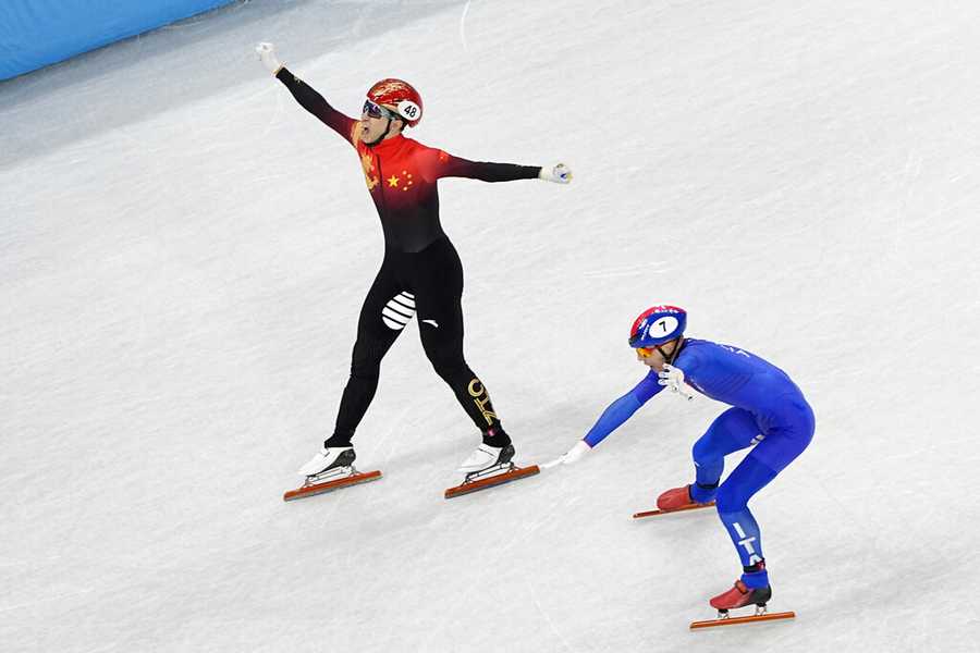 Win at home Wu Dajing, left, of China, celebrates after crossing the finish line ahead of Pietro Sighel, of Italy, to earn a gold medal for his team in the mixed relay short track speedskating competition at the 2022 Winter Olympics, Saturday, Feb. 5, 2022, in Beijing. (AP Photo/Jeff Roberson)