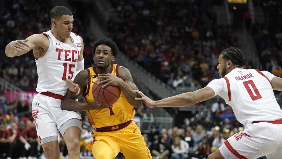 Iowa State guard Izaiah Brockington (1) drives between Texas Tech guard Kevin McCullar (15) and forward Kevin Obanor (0) during the first half of an NCAA college basketball game in the quarterfinal round of the Big 12 Conference tournament in Kansas City, Mo., Thursday, March 10, 2022. (AP Photo/Charlie Riedel)
