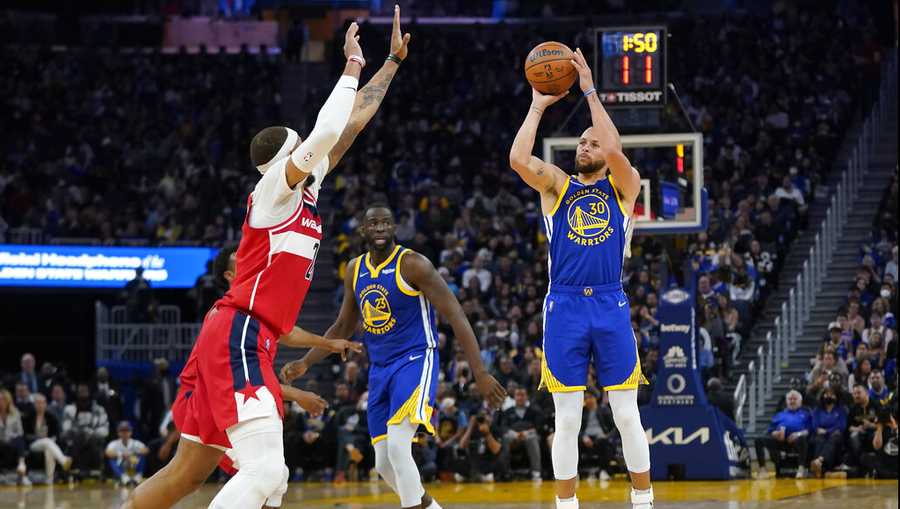 Golden State Warriors guard Stephen Curry (30) shoots a 3-point basket against Washington Wizards center Daniel Gafford during the second half of an NBA basketball game in San Francisco, Monday, March 14, 2022. (AP Photo/Jeff Chiu)