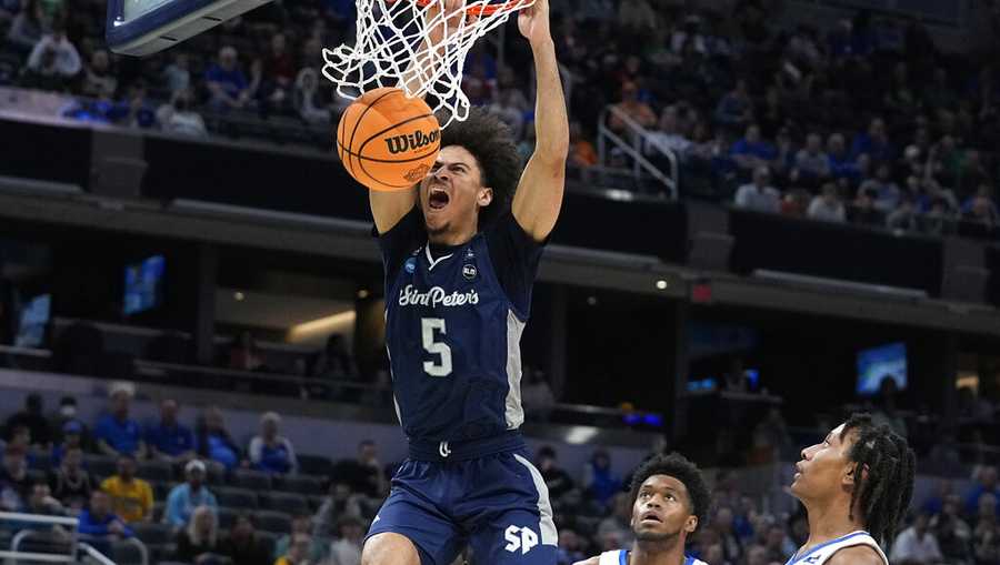 St. Peter's guard Daryl Banks III (5) dunks the gall during the first half of a college basketball game against Kentucky in the first round of the NCAA tournament, Thursday, March 17, 2022, in Indianapolis. (AP Photo/Darron Cummings)